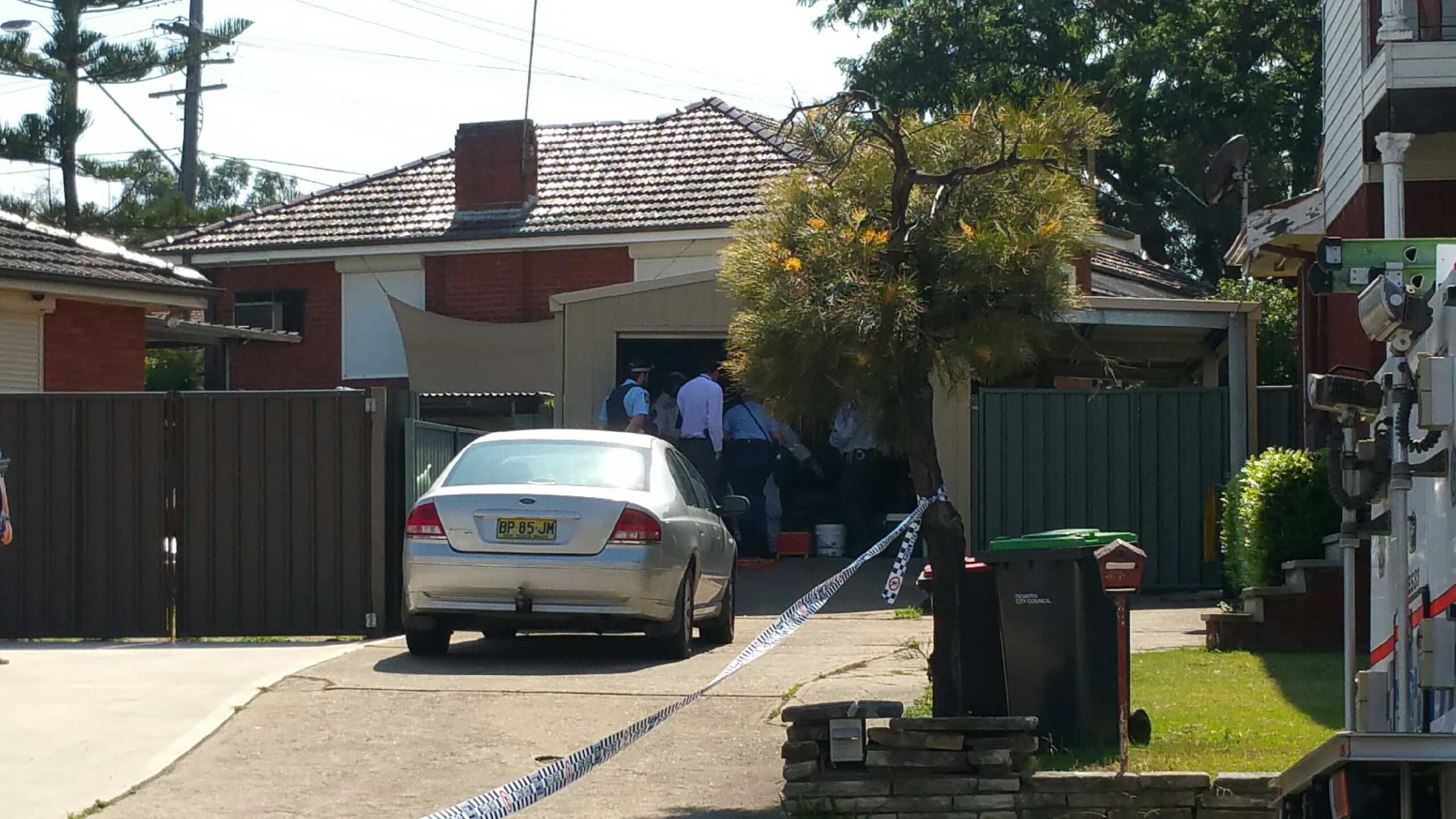 Police officers inspecting a garage. Photo: Emily Newton